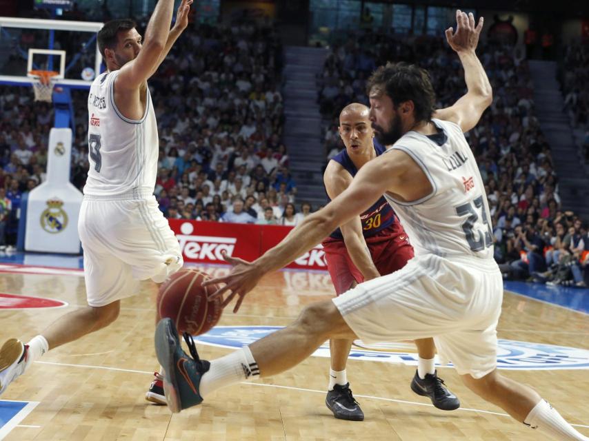 Reyes y Llull intentan impedir un pase de Arroyo.