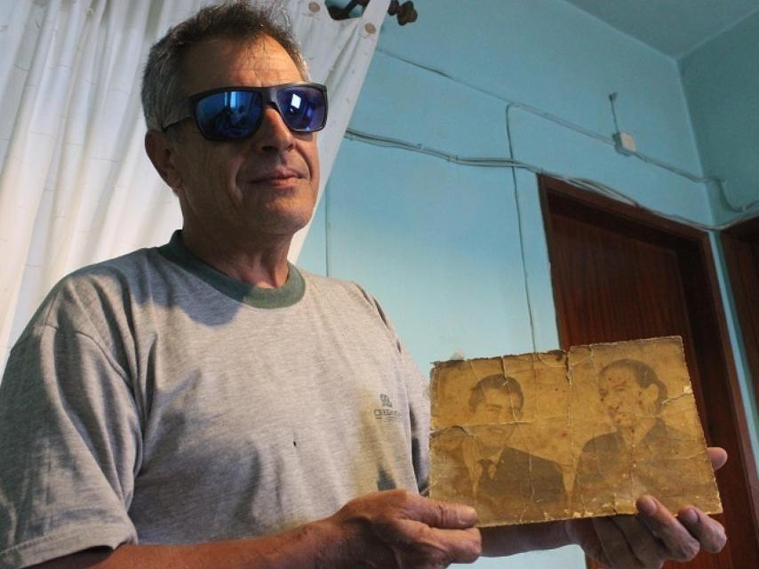 Lino, nieto de Aurora, muestra una foto de su padre y su abuela