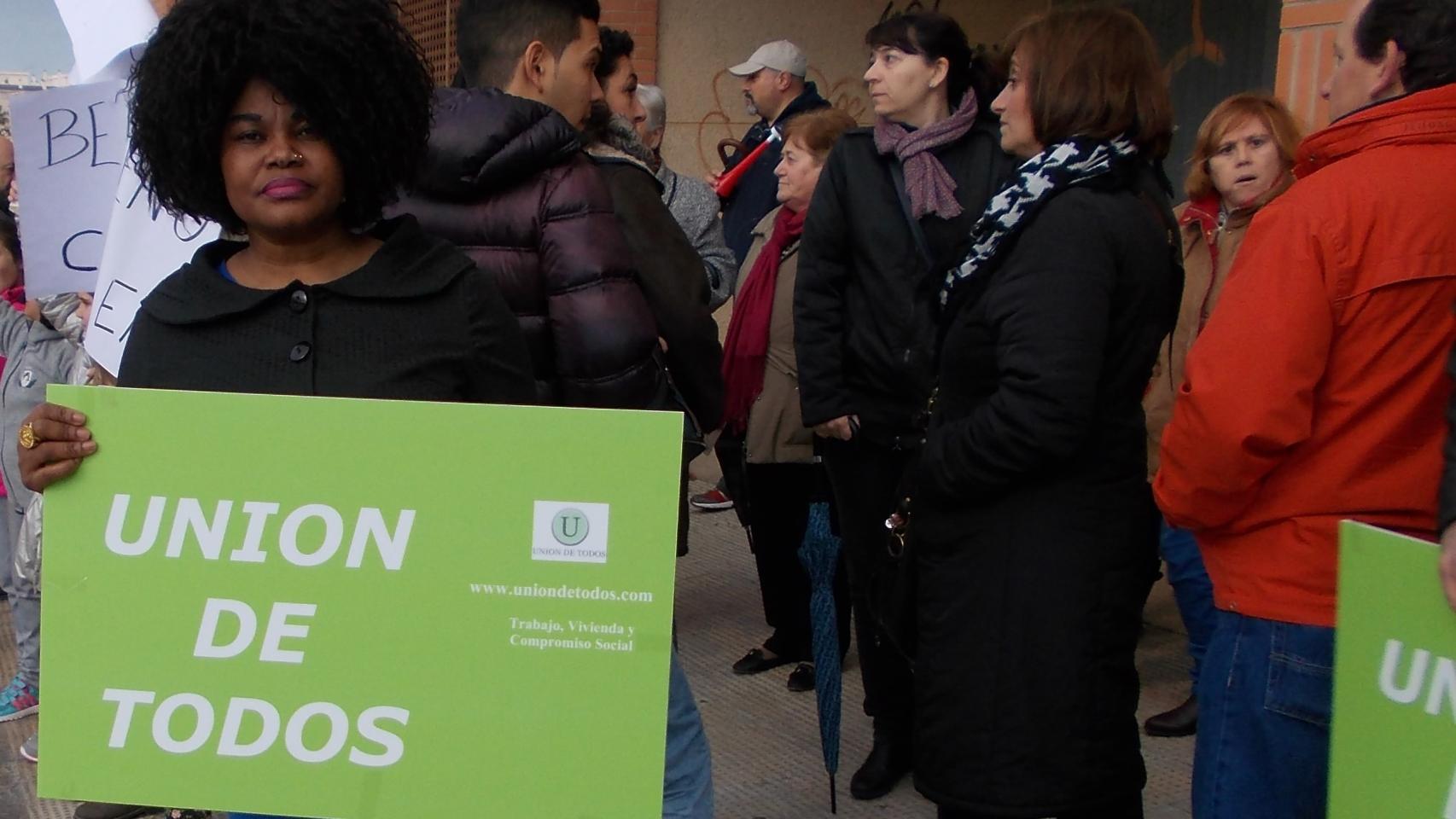 Helen Mukoro, sosteniendo el cartel de su partido, junto a militantes de Udt.