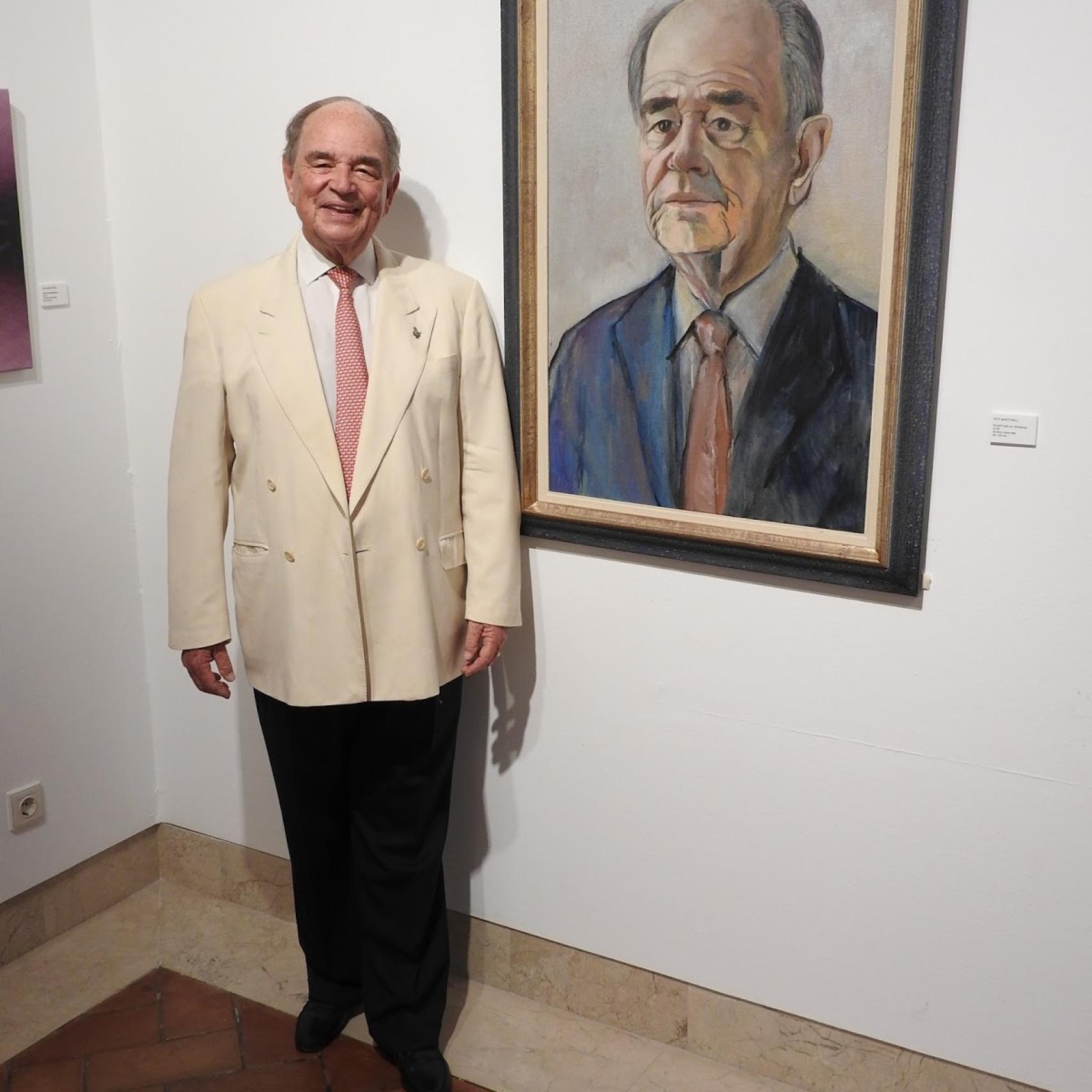 Conde Rudy posando junto a su retrato