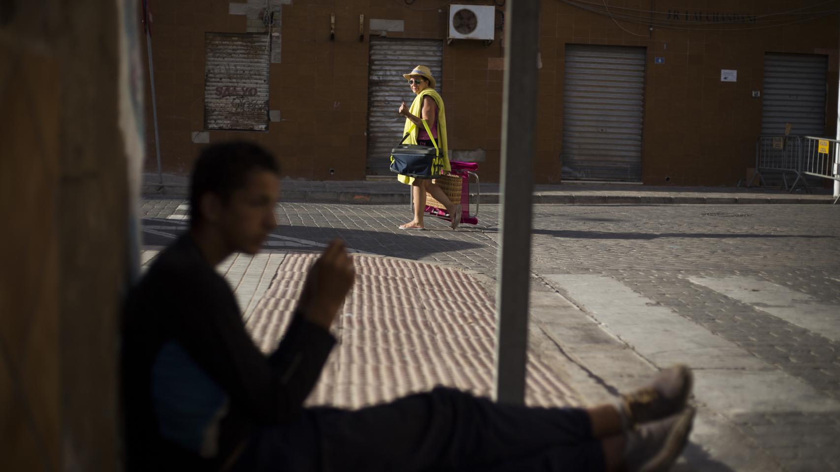 Sofyan, sentado en una esquina mientras un vecino vuelve de la playa.