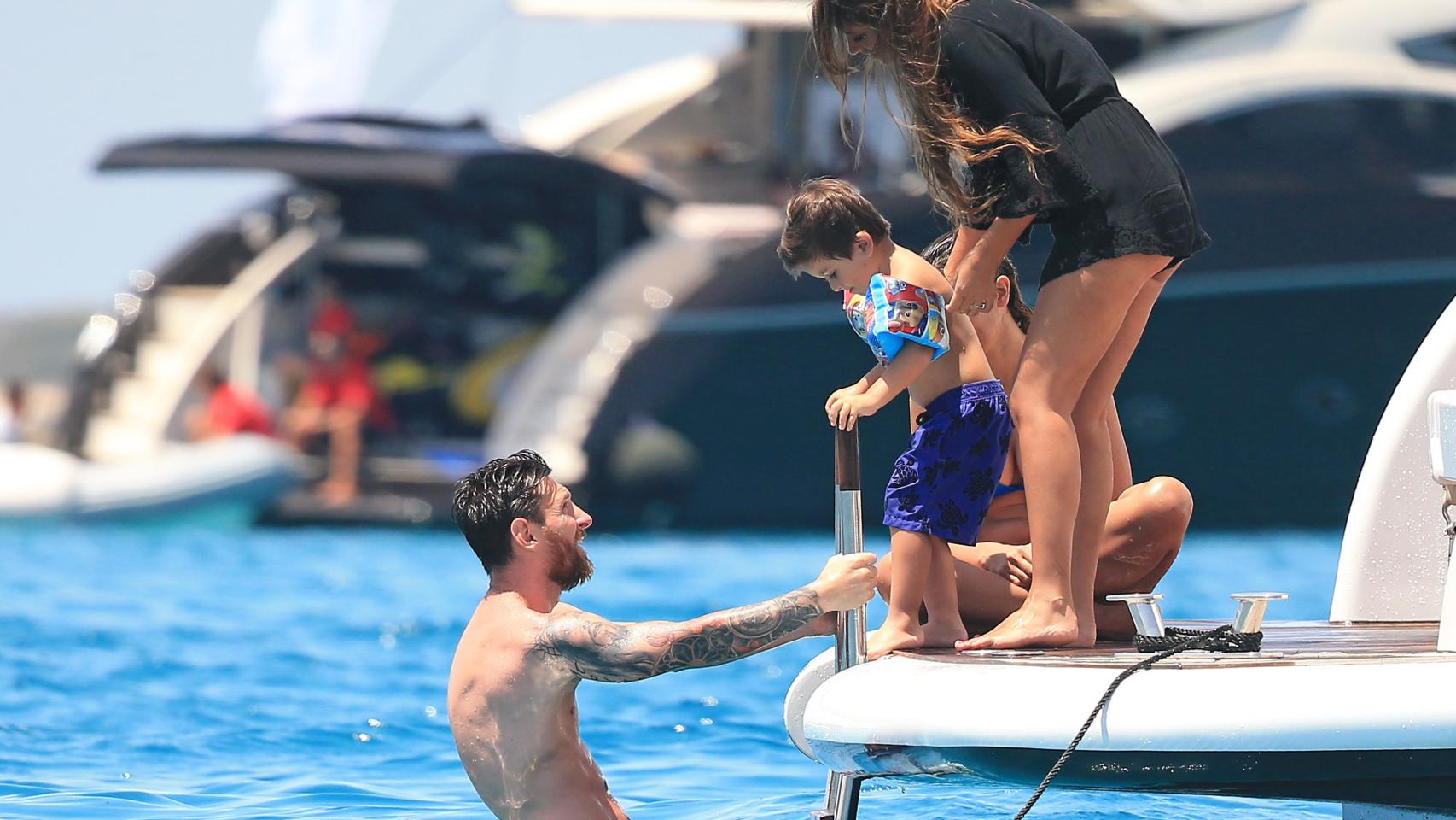 Padre y madre ayudan a su pequeño a meterse en el agua.