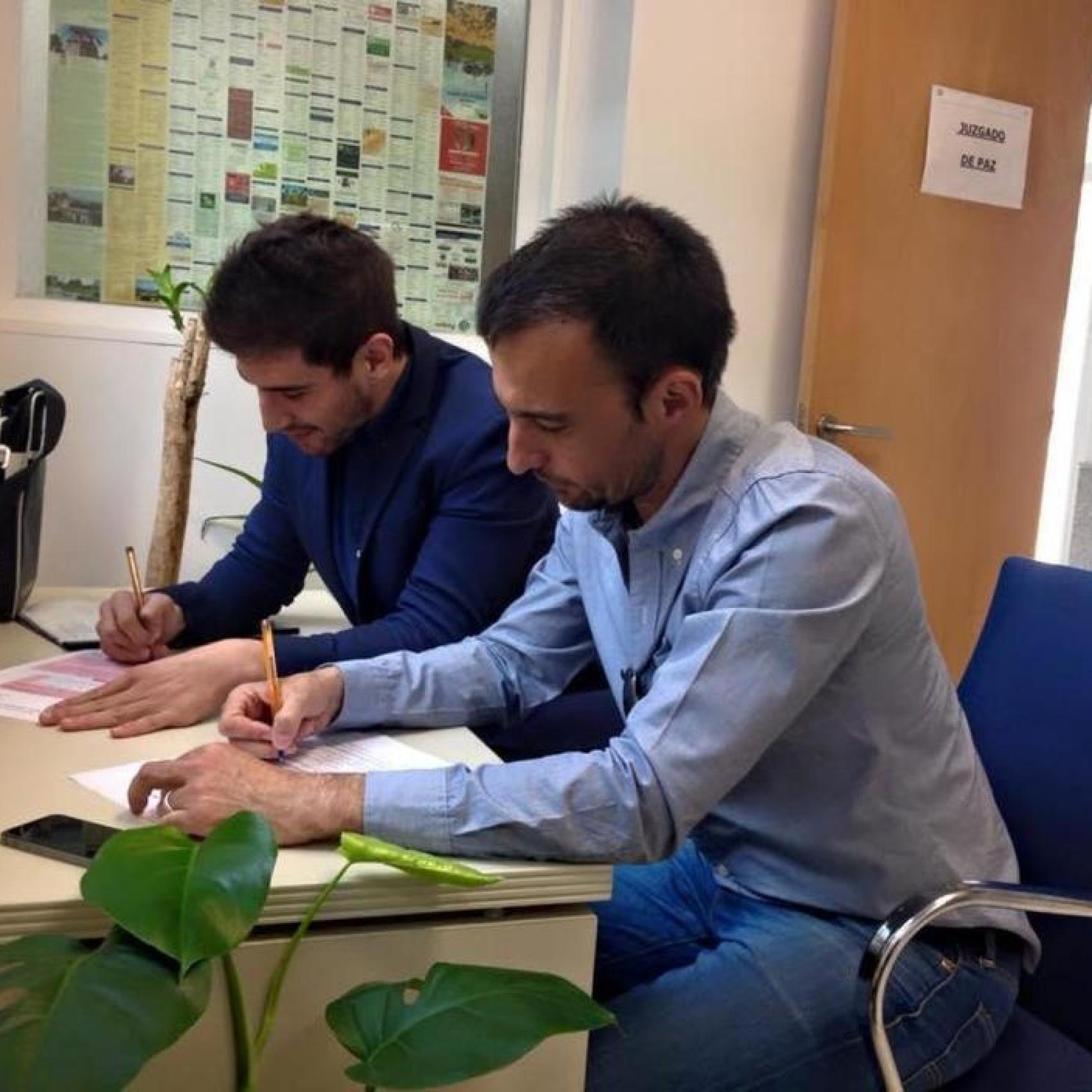 Momento en el que la pareja firma los papeles de su boda.