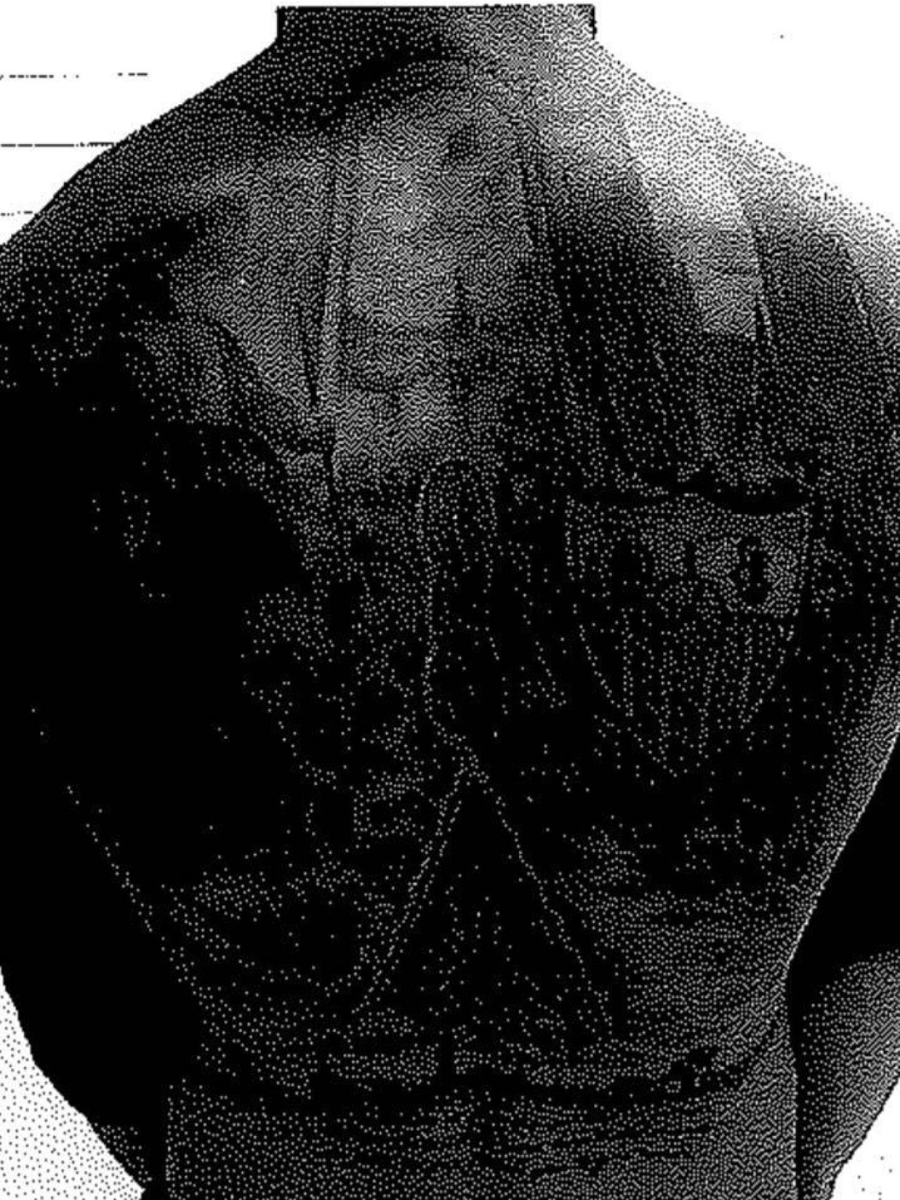 Tatuaje del escudo del Sevilla que el militar lleva en la espalda.