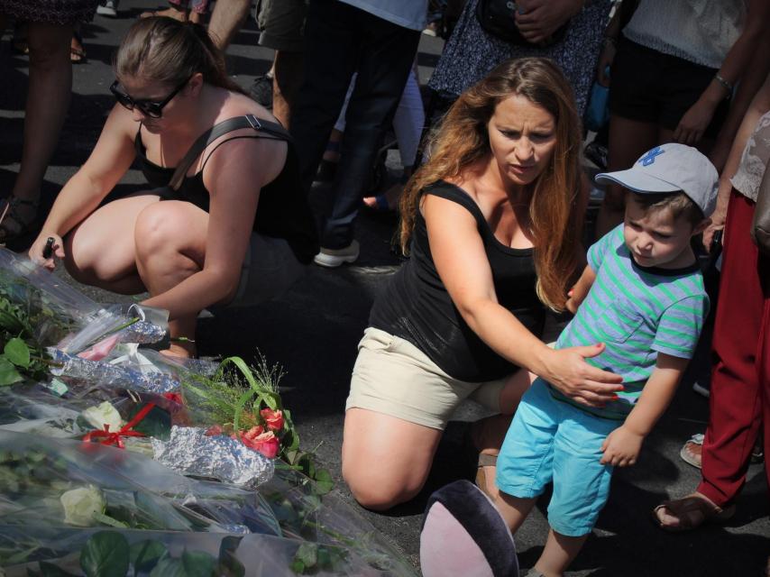 Una mujer embarazada abraza a su hijo en el Paseo de los Ingleses.