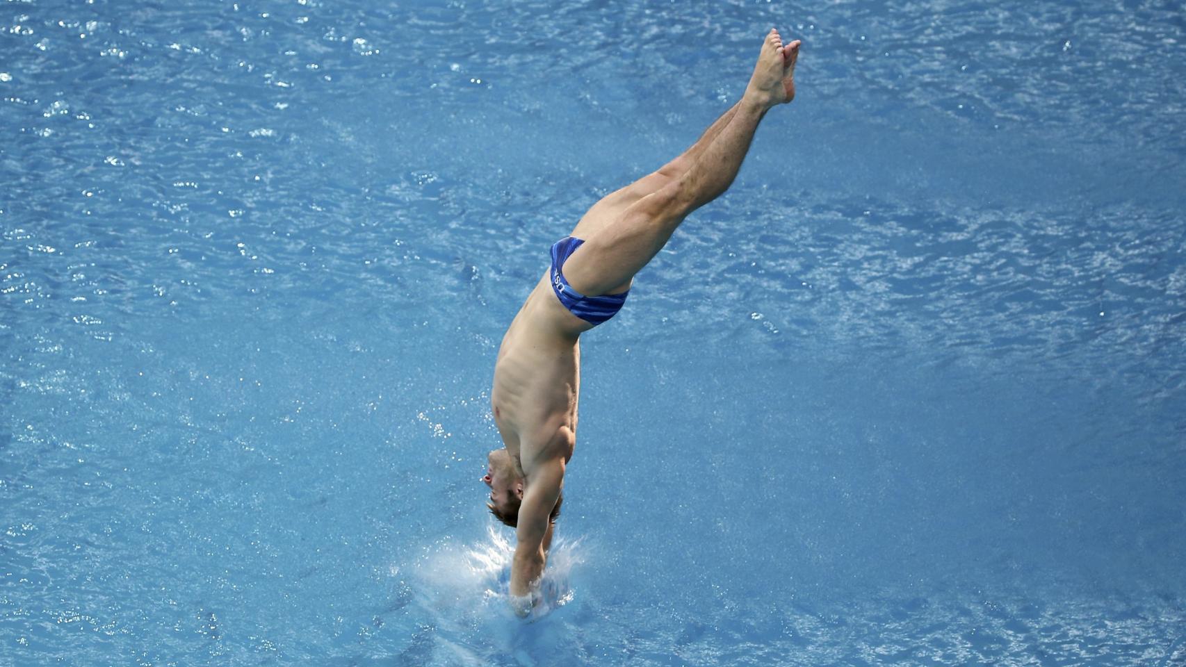 El estadounidense Mike Hixon realiza un salto en la calificación de trampolín 3 metros.