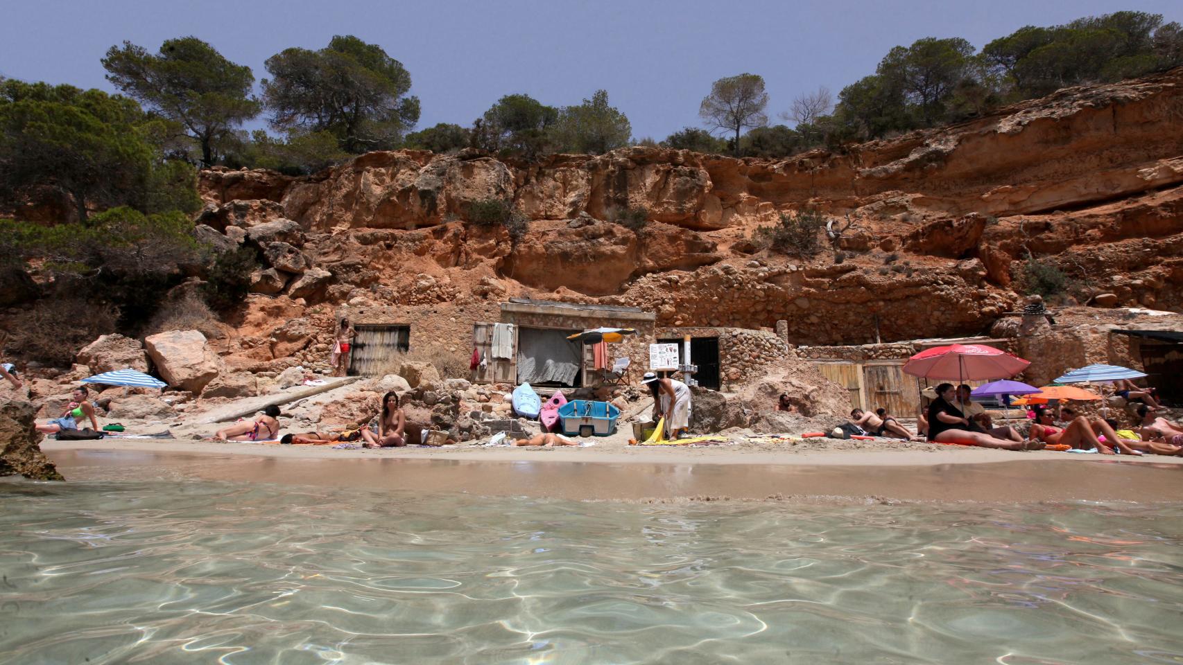 Alrededor de la cueva de Miguel, los turistas extienden sus toallas.