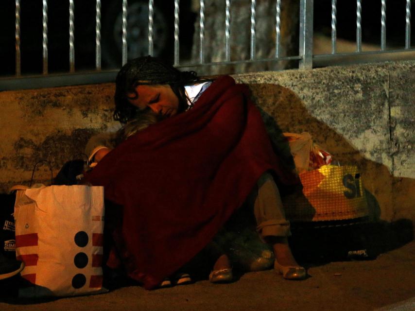 Una mujer junto a su hijo pasando la noche al raso en Amatrice.
