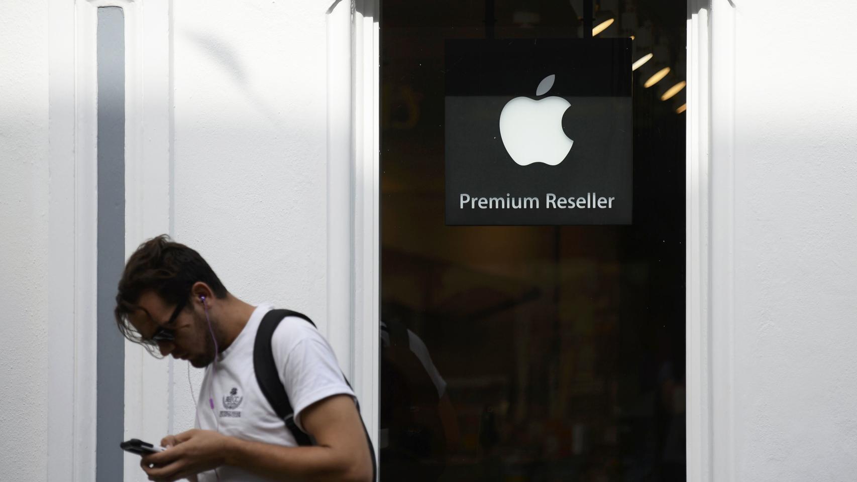 Un hombre mira su teléfono junto a una tienda en Irlanda.