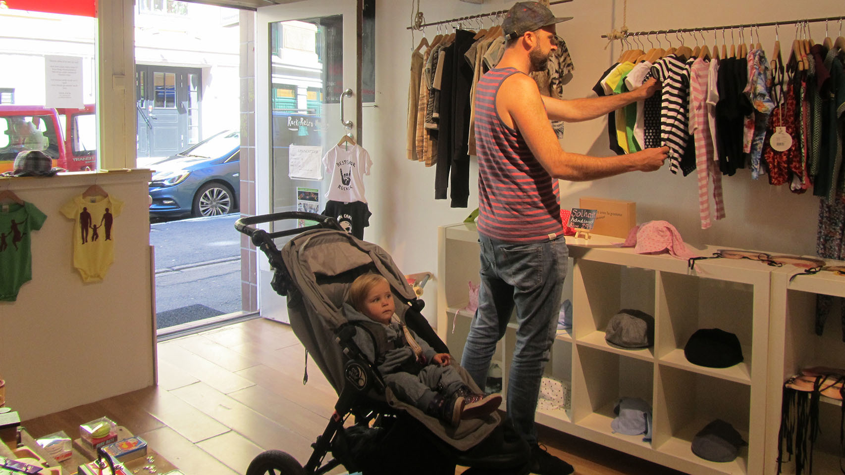 Un padre noruego, con su bebé, comprando ropita infantil en el barrio de Grünerløkka.