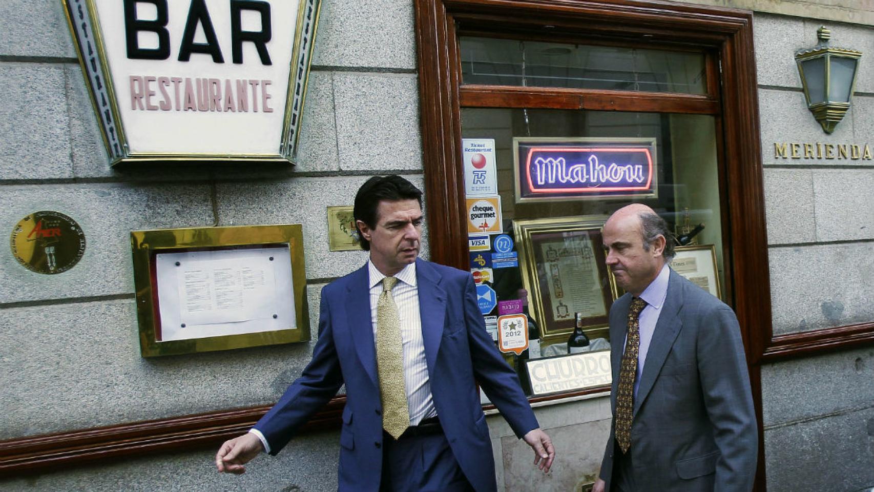 Luis de Guindos (dcha.), junto al exministro Soria (izda.) antes de entrar a un restaurante de Madrid.