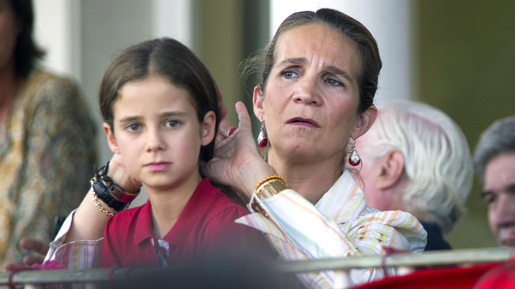 La infanta Elena recoge cariñosamente la melena de su hija.