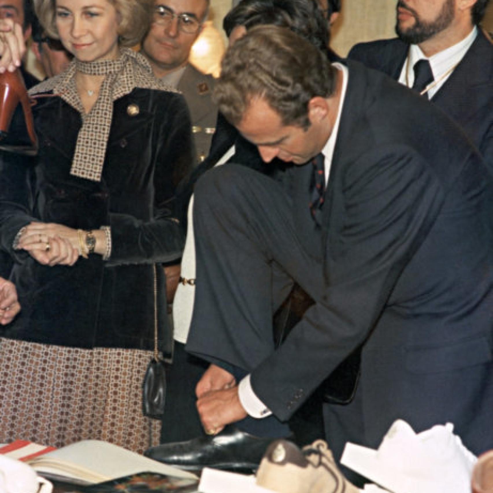 El rey emérito atándose los zapatos junto a la reina Sofía