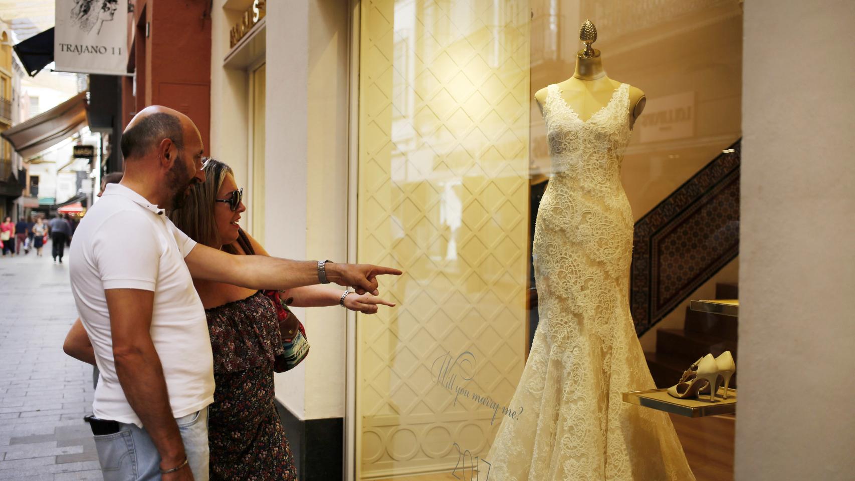 La pareja viendo un vestido de novia un escaparate