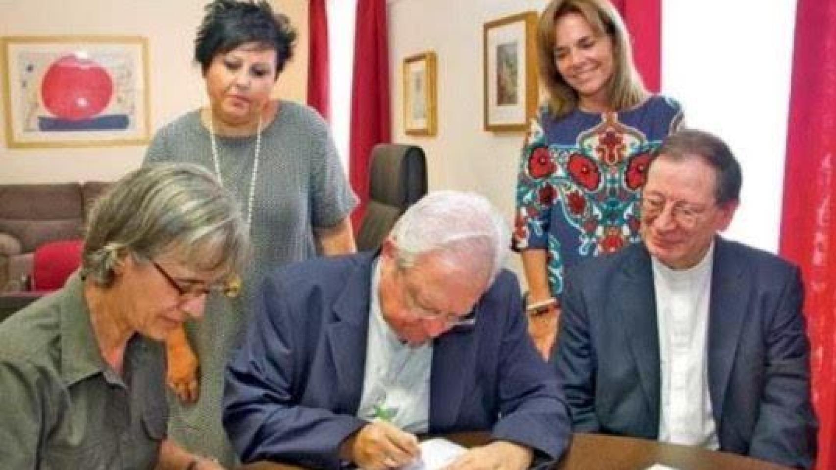 El obispo, Javier Salinas, en el centro de la imagen, firmando con el anillo episcopal y la alianza que se intercambió con Sonia Valenzuela, que aparece de pie, a la derecha.