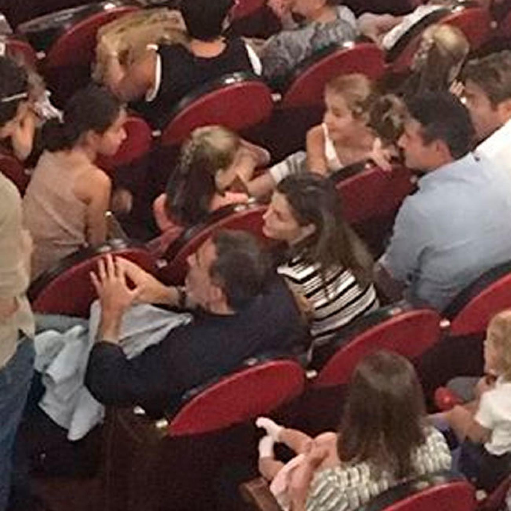 Los reyes, sus hijas y un grupo de amigos en el teatro.