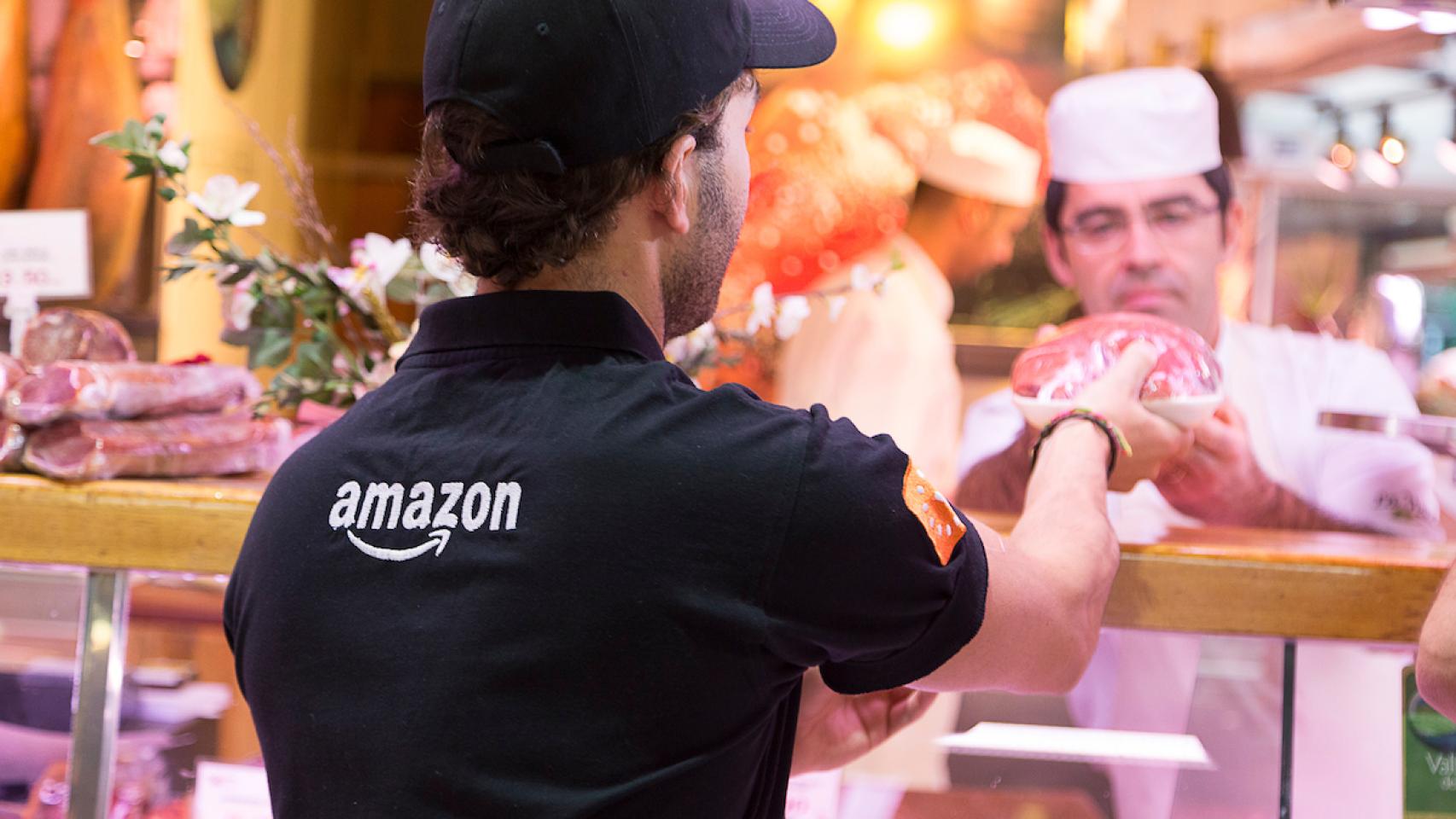 Un repartidor de Amazon recoge un producto en el Mercado de la Paz para su servicio 'Prime Now'.