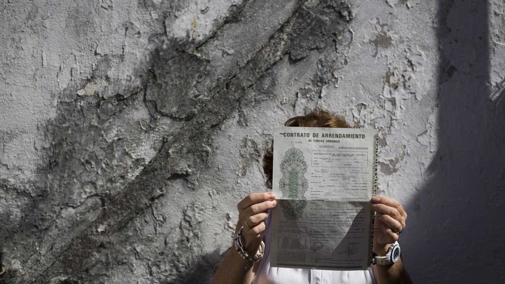 Carmen, mostrando el contrato de alquiler de la casa en la que ha pasado su vida.