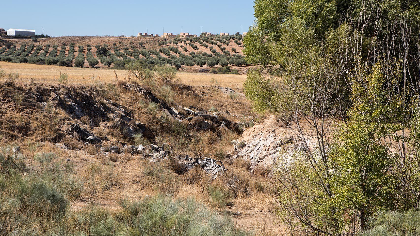 Restos tóxicos con las viviendas al fondo.