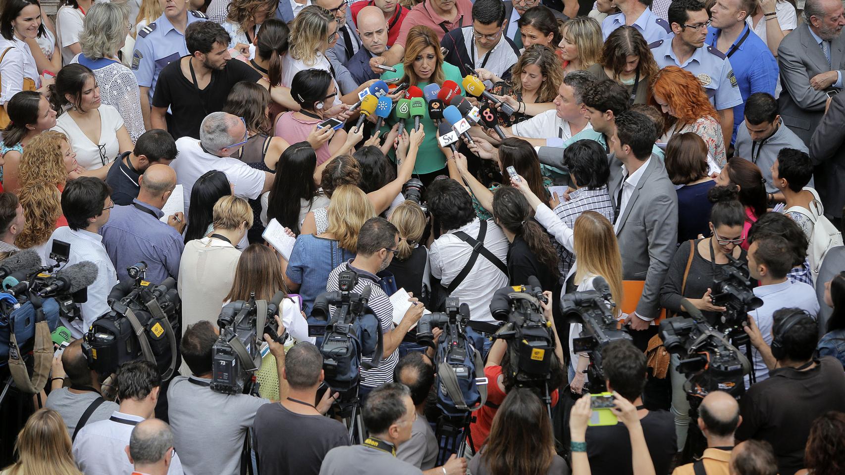 Susana Díaz habla rodeada de informadores.