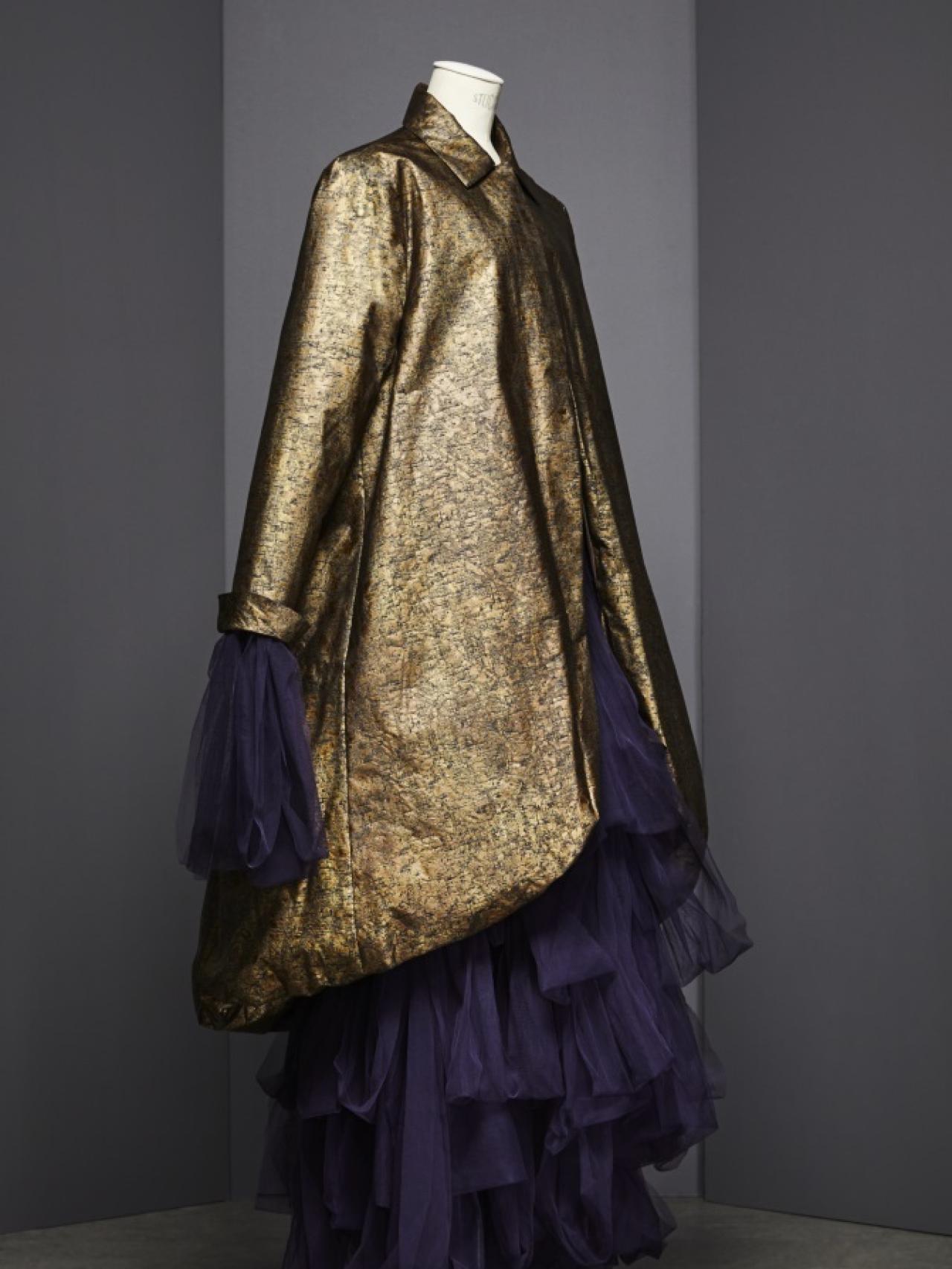 Abrigo de algodón estampado efecto envejecido con forro de seda pongee. Debajo, vestido de tul plisado a mano color morado (1995-1996).