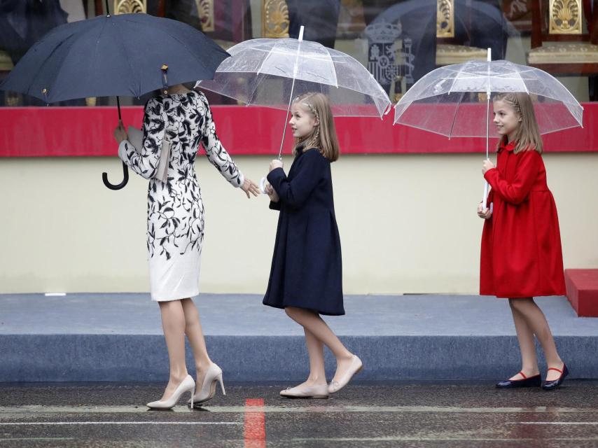 La reina camina en fila india seguida por sus dos hijas.