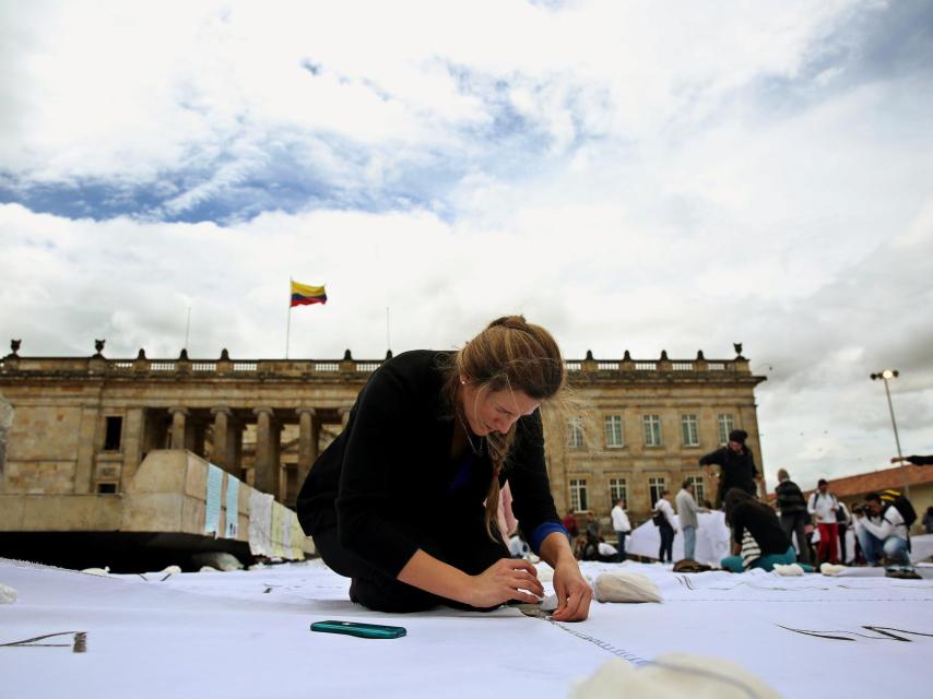 Un grupo de personas participa en una intervención artística liderada por la colombiana Doris Salcedo.
