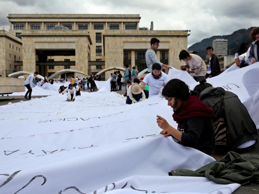 Un grupo de personas participa en una intervención artística liderada por la colombiana Doris Salcedo.