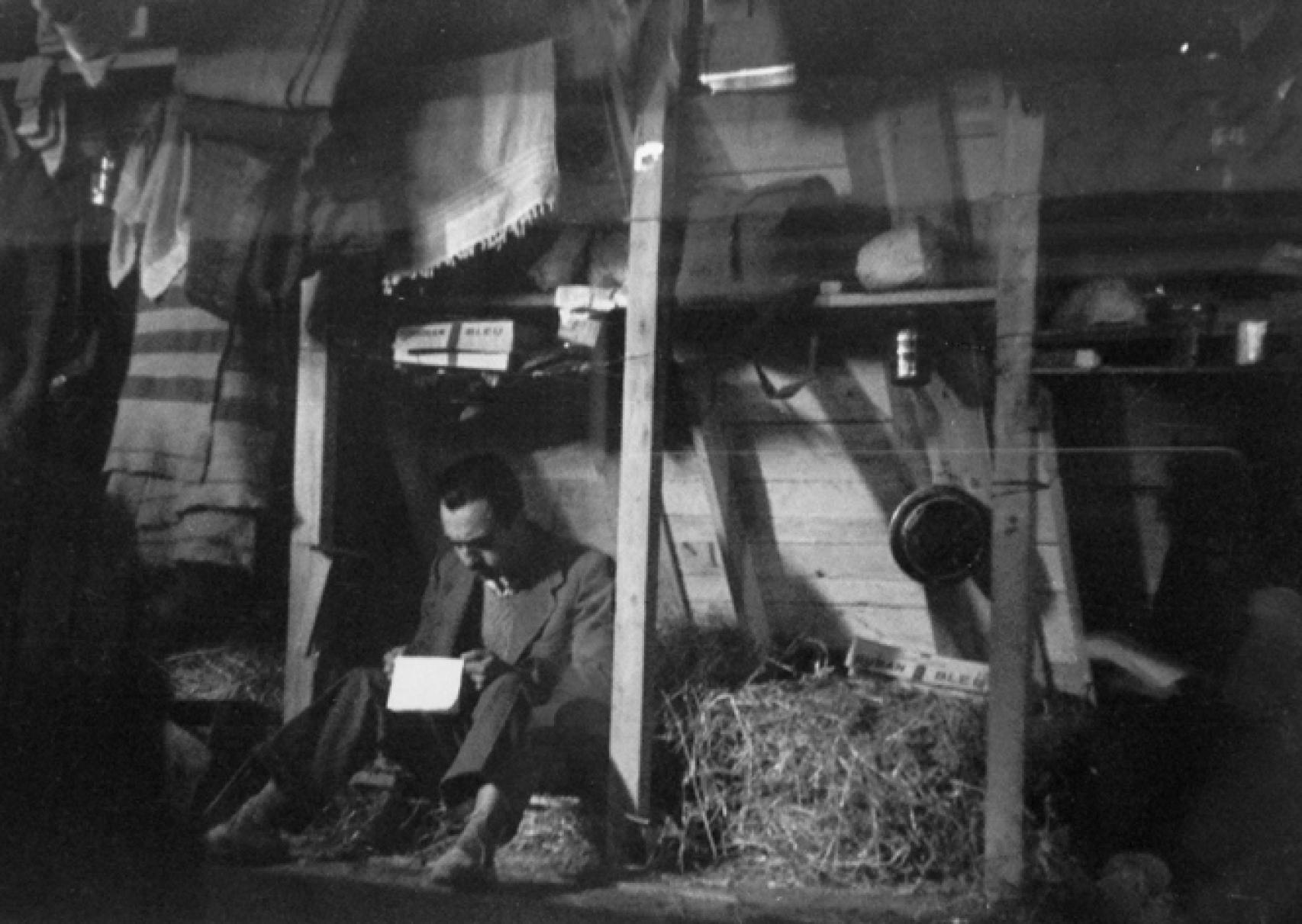 Un refugiado lee una carta en su cubículo.