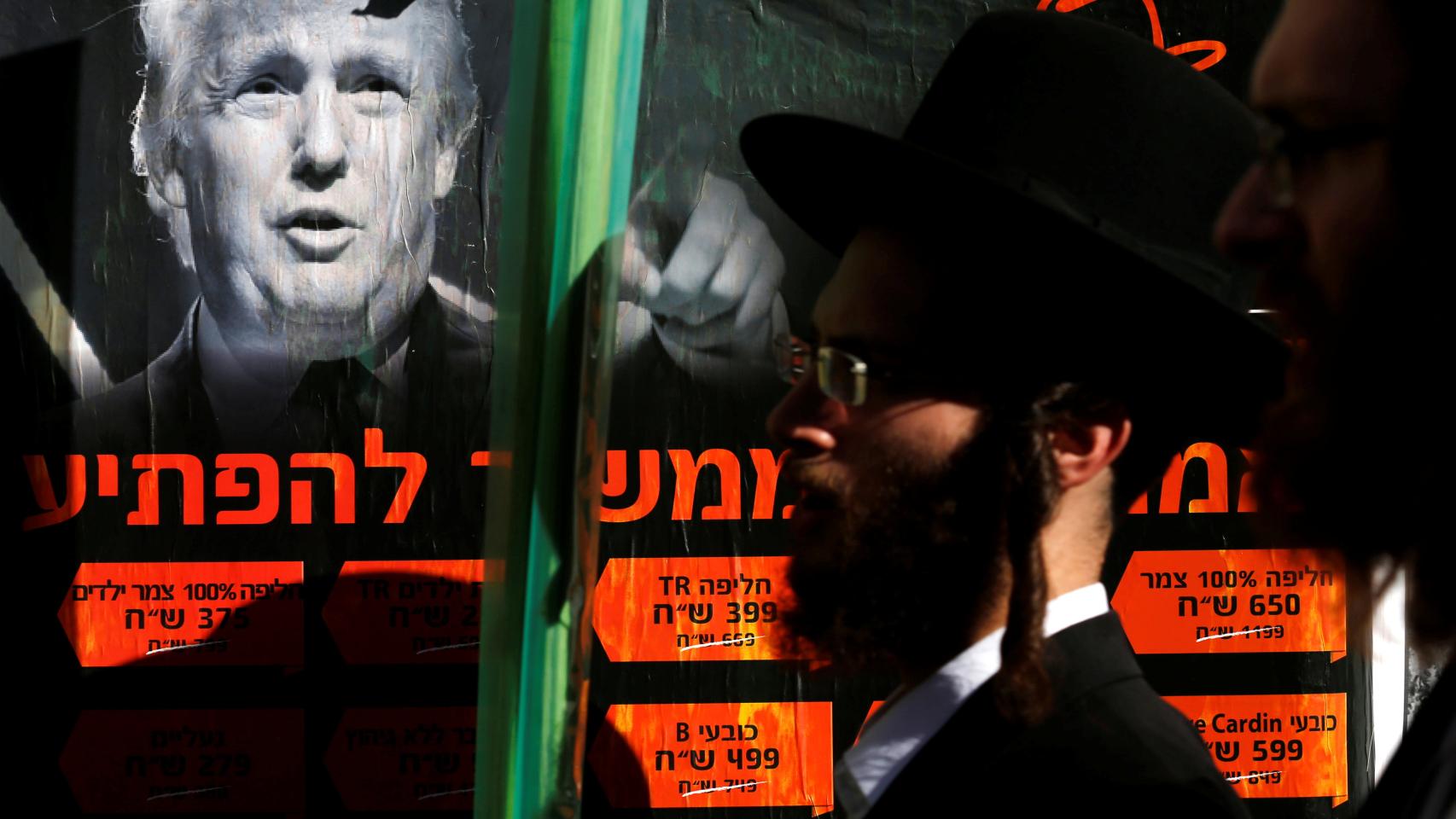 Un judío ultraortodoxo pasa junto a un póster de Trump en Jerusalén.