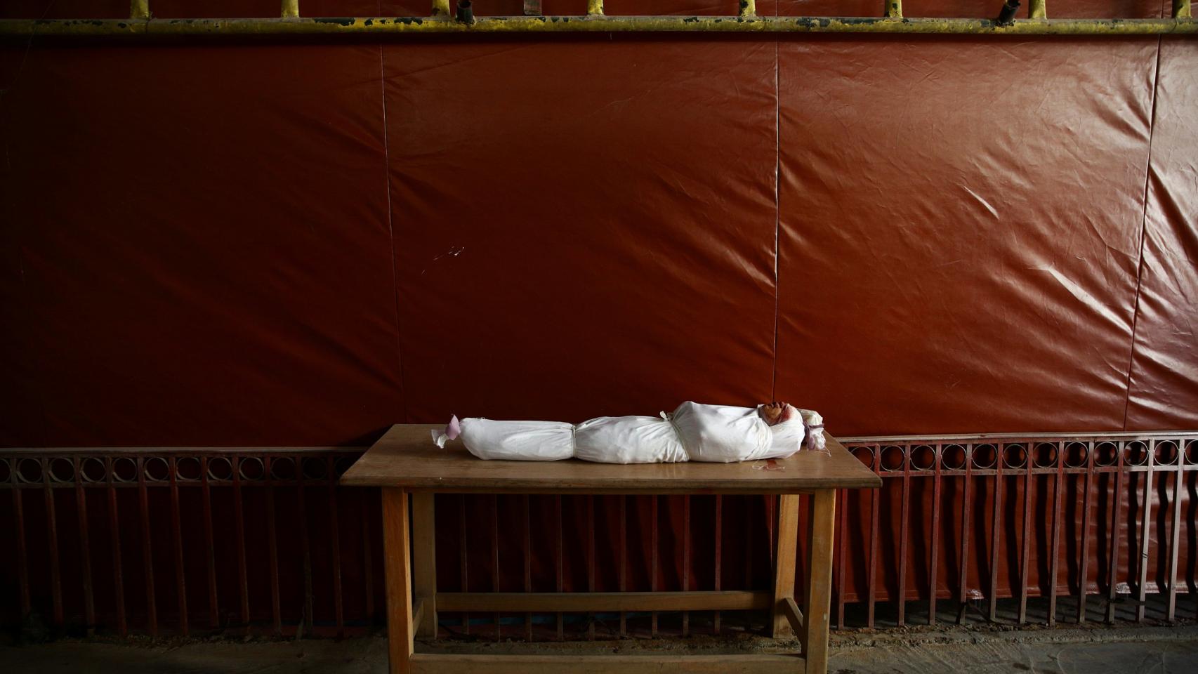 El cuerpo de un niño, envuelto en mortajas, a la espera del funeral.
