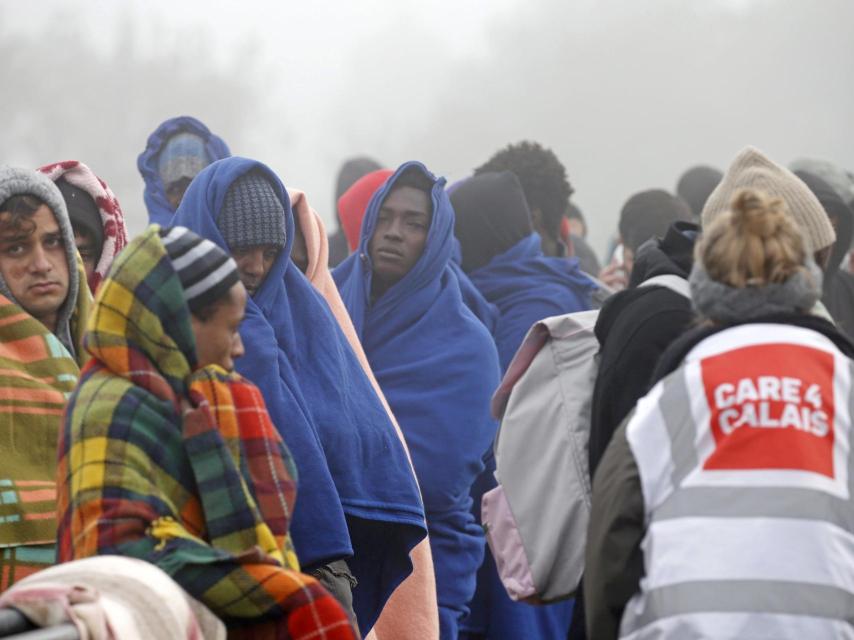 Personas que afirman ser menores hacen cola en Calais para registrarse.