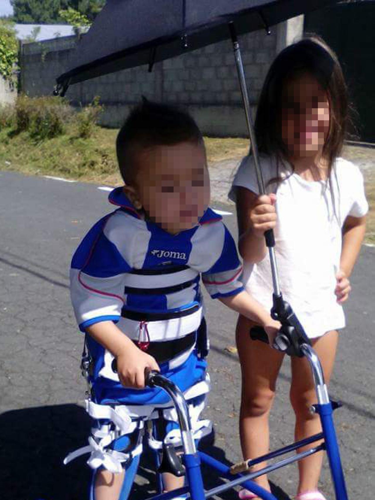 Sara sostiene el paraguas mientras su hermano Marco hace un gran esfuerzo para mantenerse erguido en los reciprocadores.