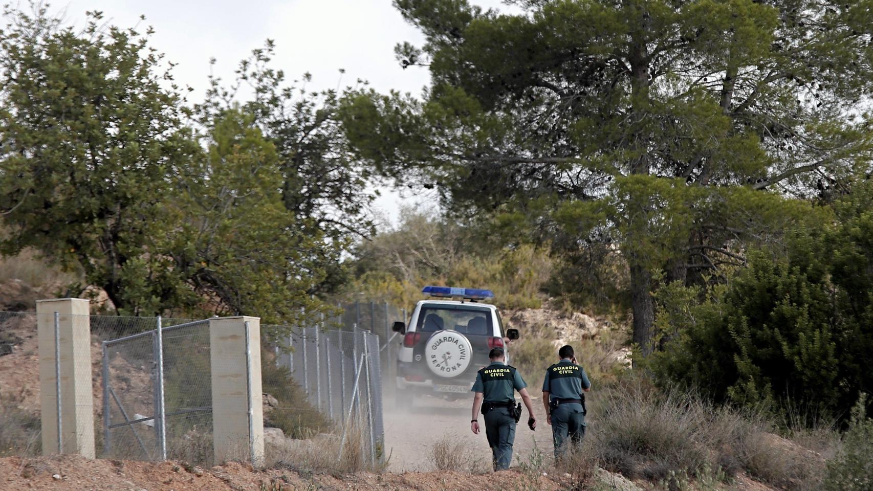 Agentes de la Guardia Civil recorren el camino de acceso al lugar donde se encontró el cuerpo.