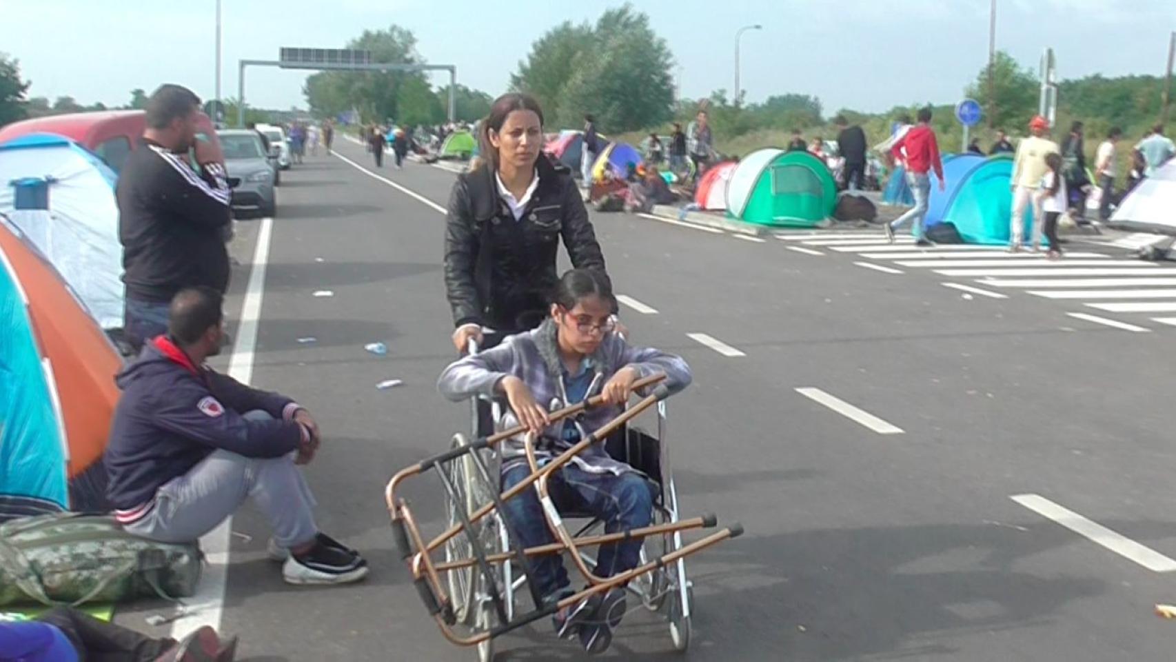 La hermana de Nujeen la ayuda para  avanzar junto a los demás demandantes de asilo.