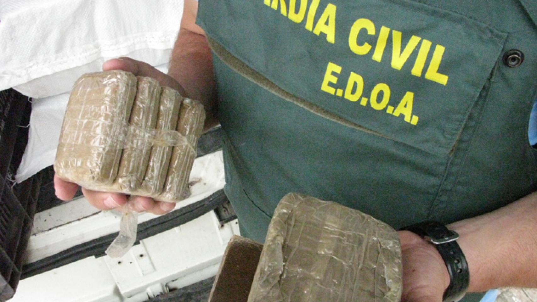 Un agente del EDOA sostiene varias placas de hachís decomisadas durante un operativo de la Benemérita.