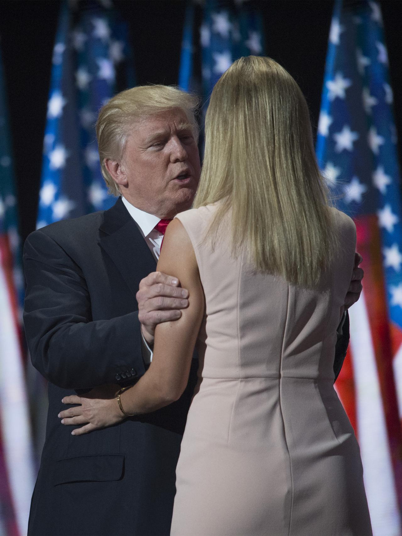 Padre e hija saludándose durante un acto de campaña