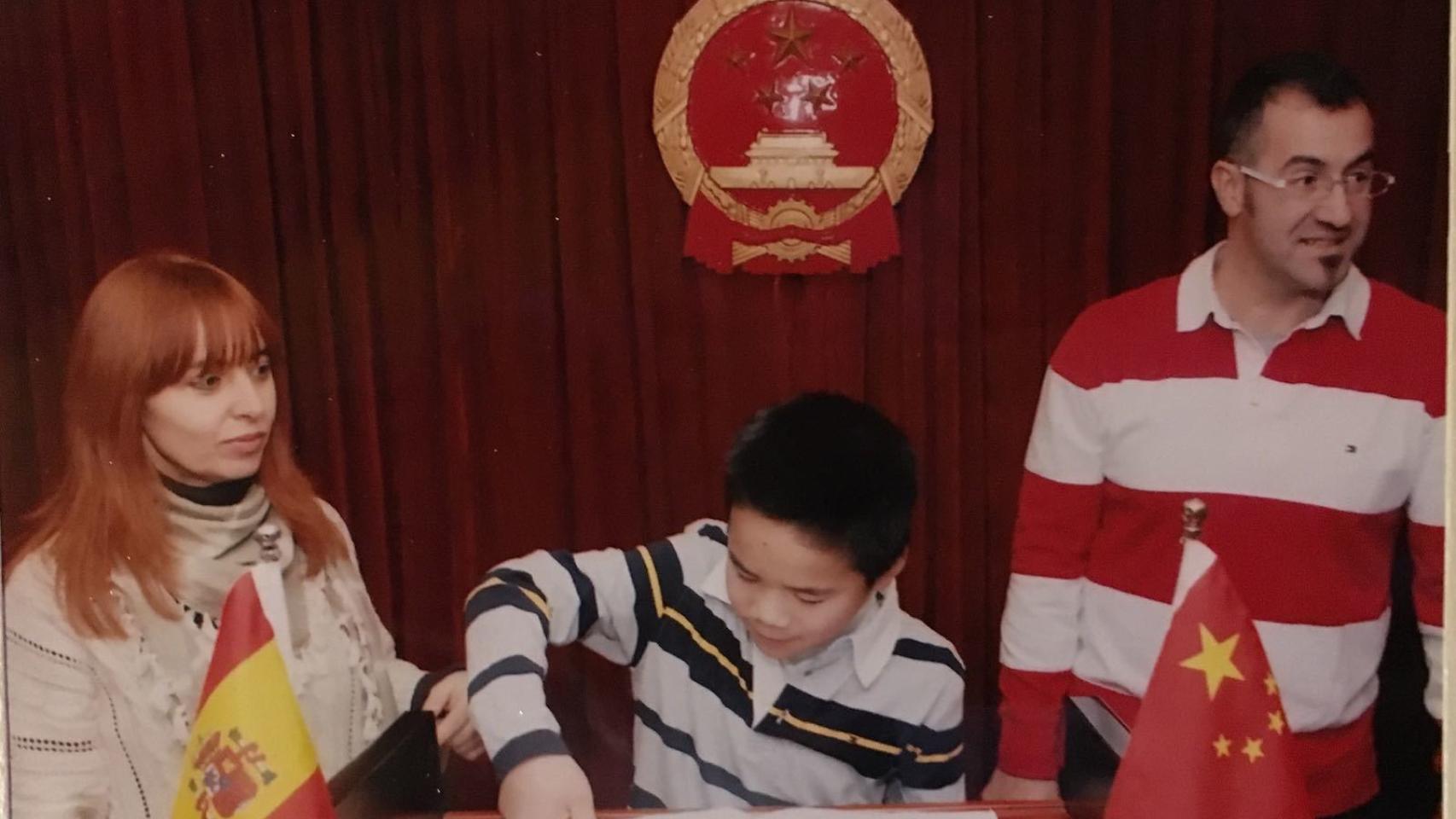 Daniel y sus padres firmando los papeles de adopción.