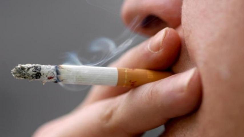 Un hombre se fuma un cigarrillo.