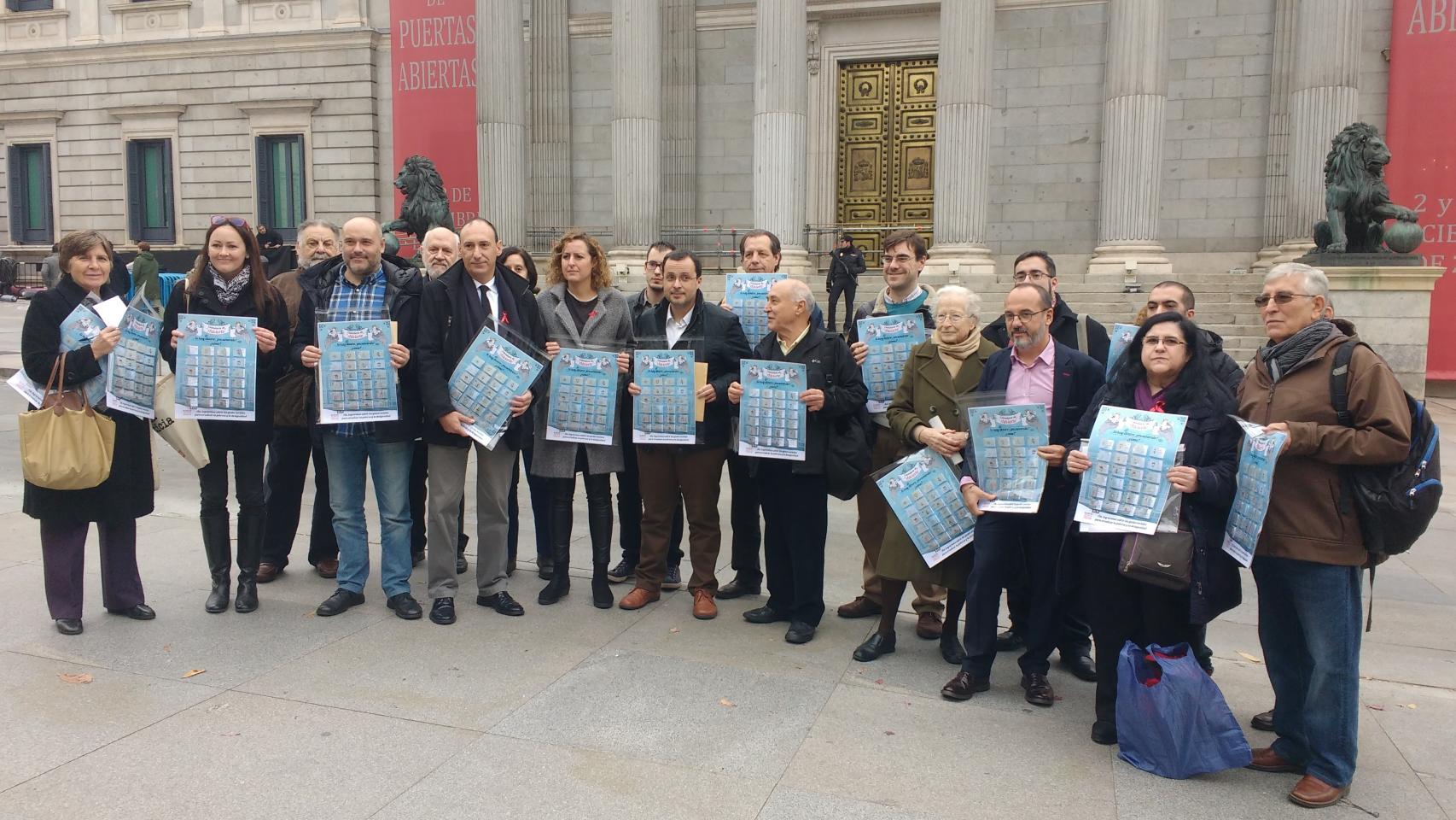 Miembros de la Alianza contra la Pobreza posan con los portavoces de la comisión de Hacienda.