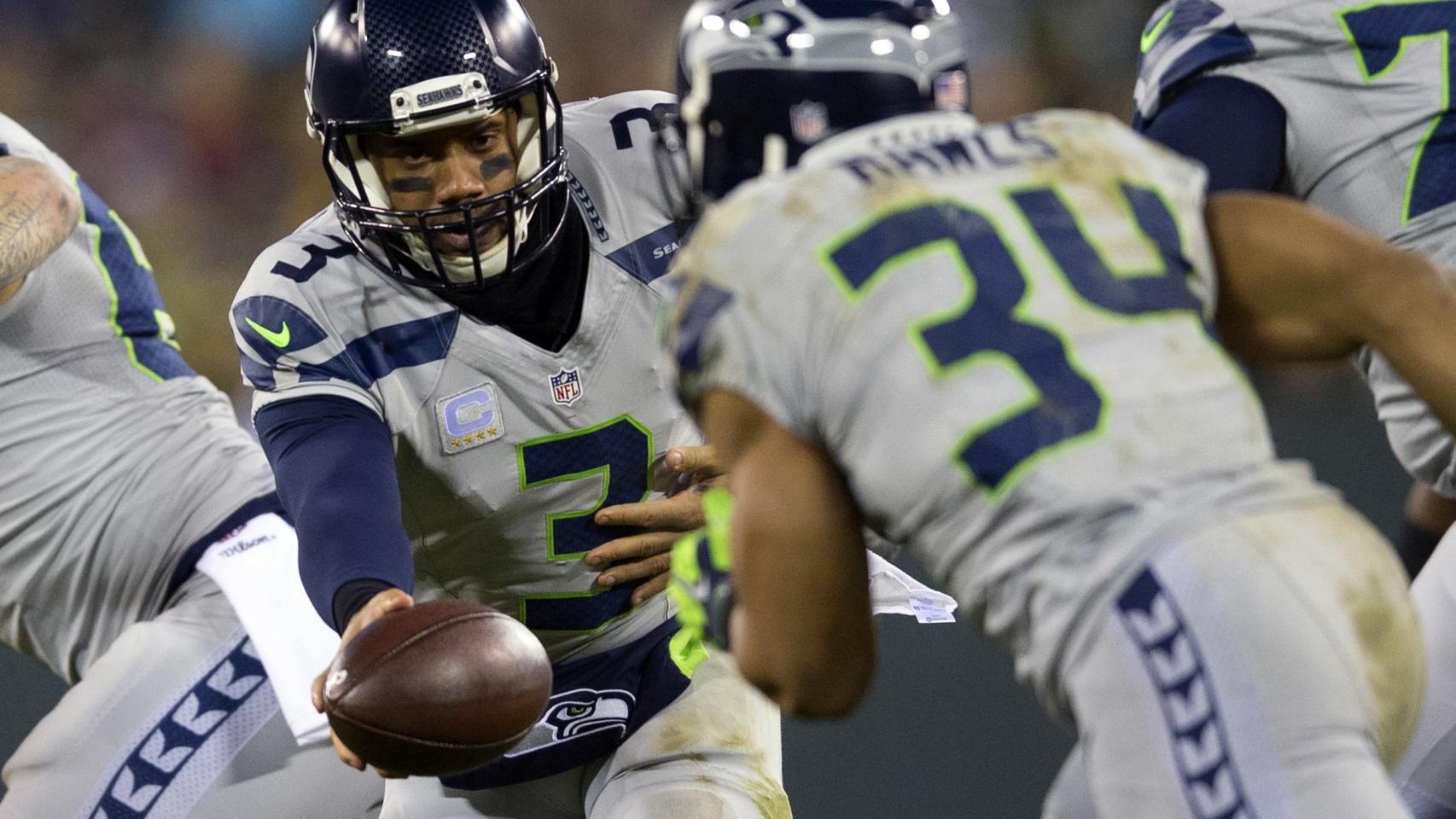 Russell Wilson le pasa el balón a Thomas Rawls en un partido de los Seahawks.