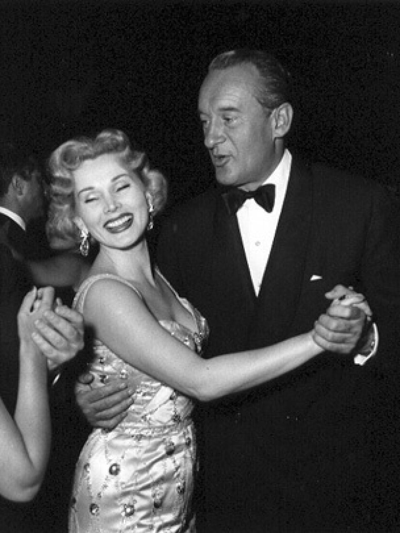 George Sanders y la actriz bailando.