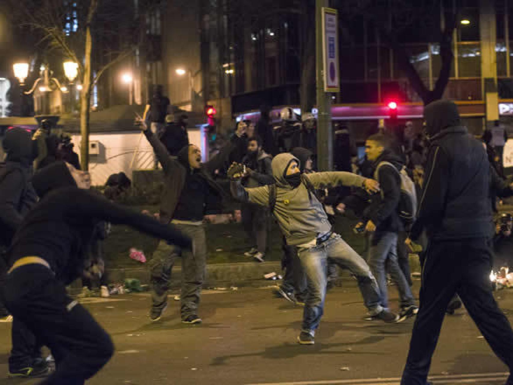 Varios jóvenes lanzan objetos al término de las marchas por la dignidad convocada en Madrid.
