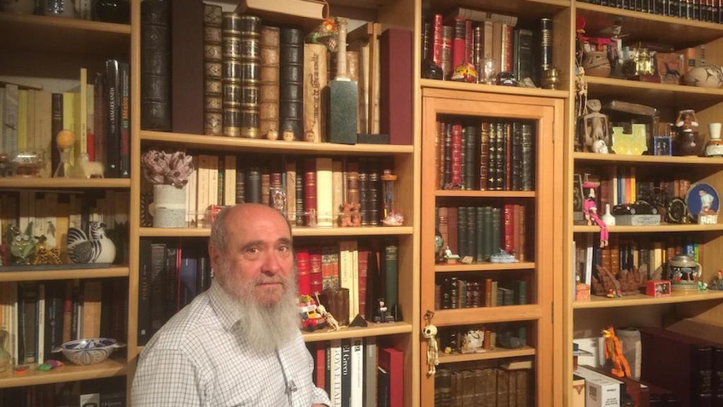Miguel Botella junto a una parte de su biblioteca particular