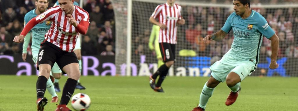 Aymeric Laporte disputa un balón con Luis Suárez.