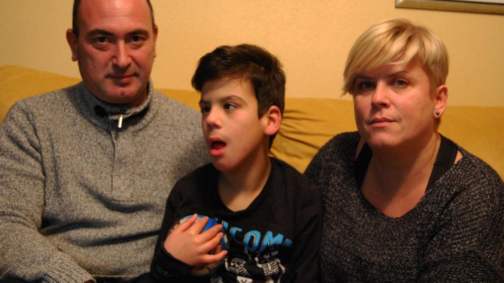 Miguel, junto a sus padres, en su domicilio de Zaragoza.