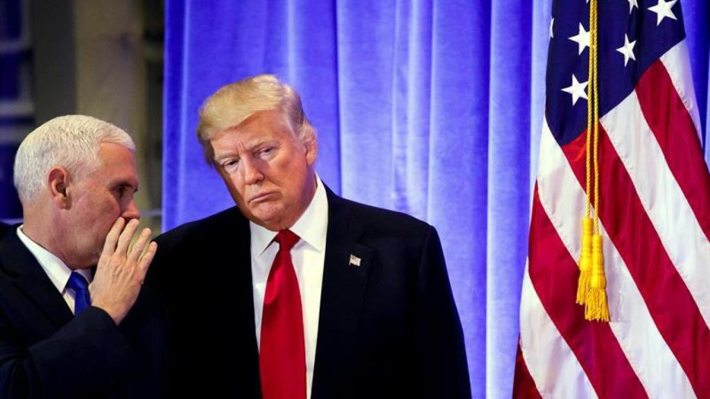 El vicepresidente electo, Mike Pence, habla con Trump durante una rueda de prensa.