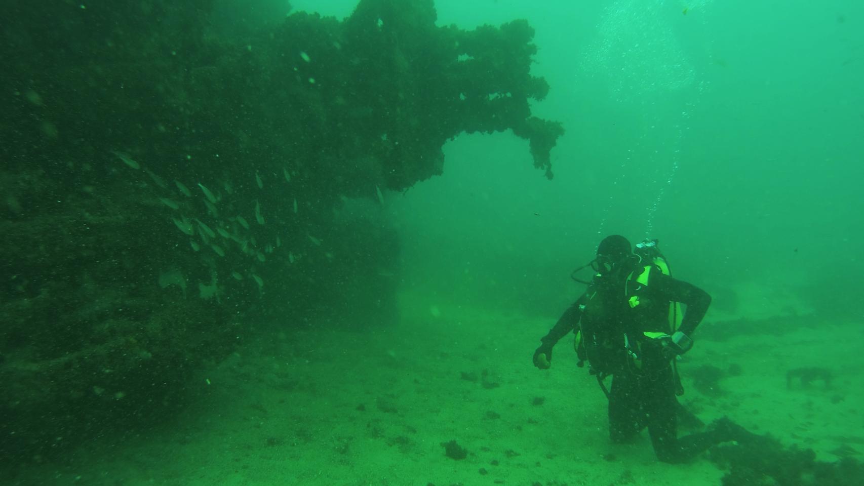 Un submarinista de la Armada junto al pecio de una embarcación.
