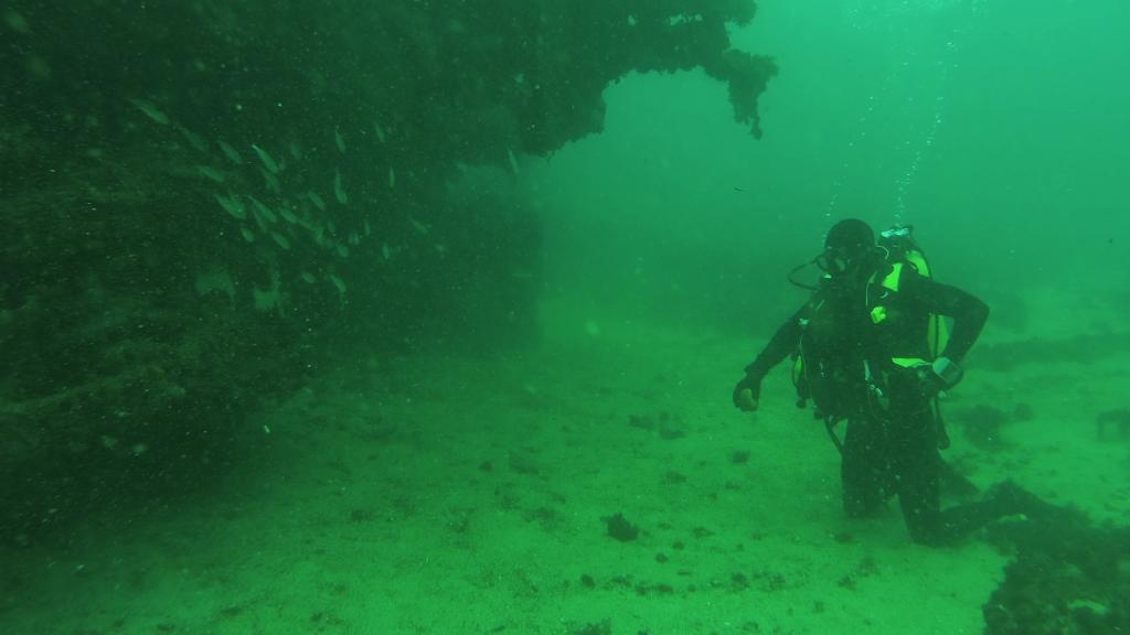 Un submarinista de la Armada junto al pecio de una embarcación.