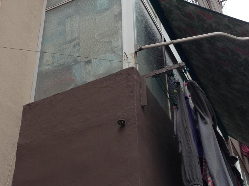 Balcón acristalado de la casa de la familia fallecida, donde aún permanecen los bultos que acumulaban.
